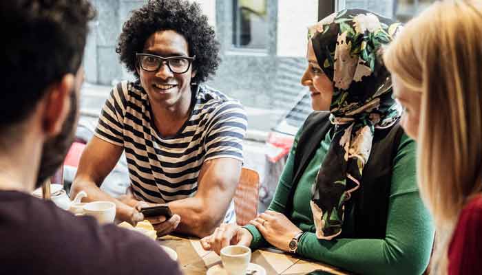 A group of people sitting around a table and talking